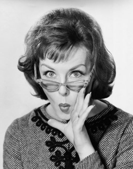 Portrait of a young woman puckering with hand near mouth poster print