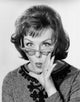 Portrait of a young woman puckering with hand near mouth poster print
