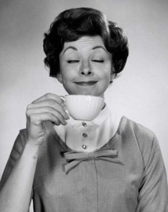 Portrait of a young woman enjoying a cup of tea poster print.