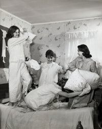 Four teenage girls having a fun pillow fight poster print