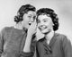 Portrait of a teenage girl whispering to another teenage girl poster print.