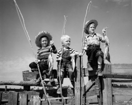 Boys sitting on a fence holding fishing rods and fish poster print.