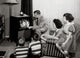 Parents with three children watching television poster print
