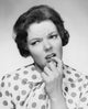 Close-up poster print of a mid adult woman with her finger in her mouth.