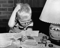 Boy scratching his head while looking at bills poster print.