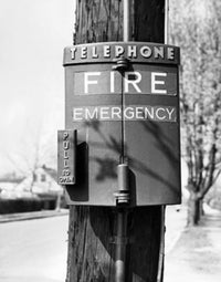 Close-up fire alarm mounted on a wooden post poster print