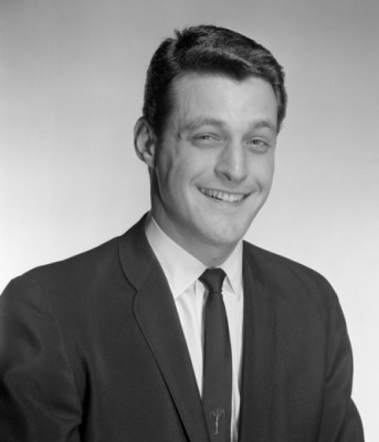 Studio portrait of a businessman smiling, perfect for office decor.