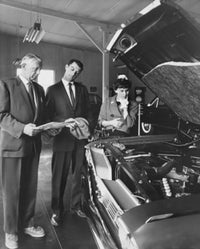 Senior man showing a car to a couple in a showroom poster print