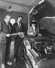 Senior man showing a car to a couple in a showroom poster print
