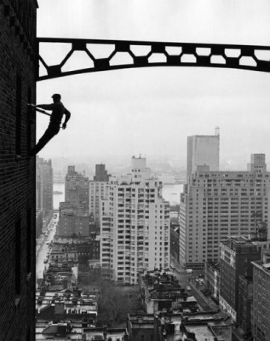 Silhouette of a Window Cleaner Poster Print featuring a worker cleaning windows high above a cityscape.