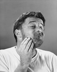 Close-up poster print of a mid-adult man scratching his head.