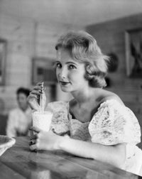 Portrait of a young woman drinking a milkshake at a bar counter, art print