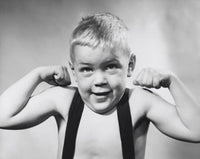 Studio portrait of a boy flexing muscles, inspiring artwork for kids' rooms.