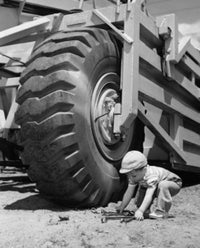 Toddler Picking Up Wrenches Poster Print showcasing a child in a playful moment.