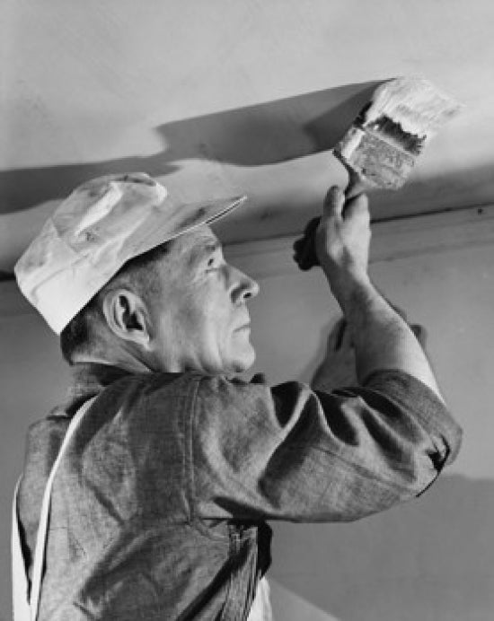Low angle view of a painter painting the ceiling of a house poster print.