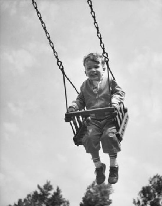 Low angle view of a boy swinging on a swing poster print.