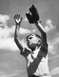 Low angle view of a boy wearing a baseball glove with arms raised poster print.