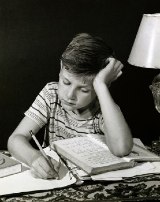Close-Up of a Boy Studying Poster Print showcasing a moment of concentration.