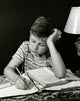 Close-Up of a Boy Studying Poster Print showcasing a moment of concentration.