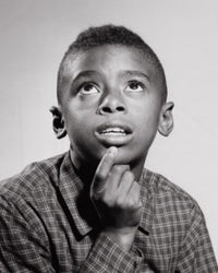 Close-up of a boy looking up poster print, capturing childhood wonder.