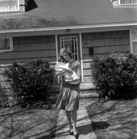 Mother carrying baby outside house poster print