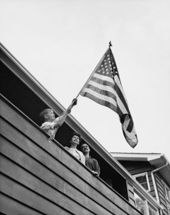 Boy holding an American flag poster print, low angle view