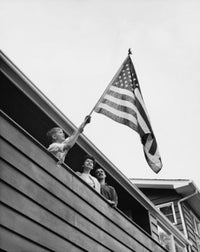 Boy holding an American flag poster print, low angle view