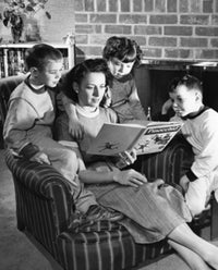 Close-up of a mother reading a storybook with her son and daughter
