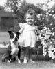 Baby Girl with Dog in Garden Poster Print