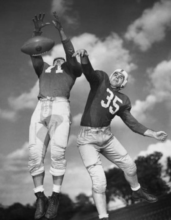 Two football players in action poster print, low angle view.