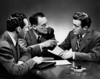 Vintage photograph of businessmen in a meeting, showcasing classic style and historical significance.