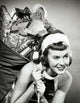 Close-up of a young woman joyfully carrying a sack of Christmas presents.
