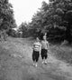 Vintage photograph of boys walking on a forest footpath, nostalgic print