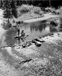 Vintage photograph of children fly-fishing on a wooden raft
