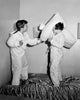 Side profile of two girls having a pillow fight poster print.