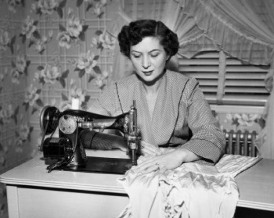 Mid adult woman sewing clothes with a sewing machine poster print