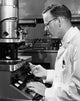 Side profile of a scientist working on an electron microscope poster print.