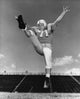 Low angle view of a football player kicking a ball, sports poster print