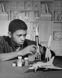 Teenage boy building airplane and rocket models poster print.