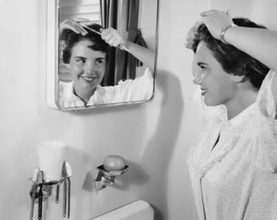 Teenage girl combing her hair and smiling poster print