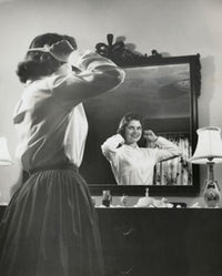 Side profile of a teenage girl combing her hair in front of a mirror poster print.
