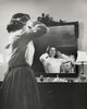 Side profile of a teenage girl combing her hair in front of a mirror poster print.
