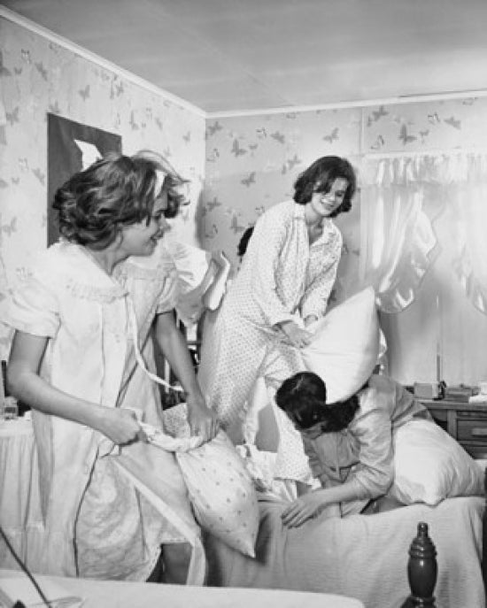Four teenage girls having a pillow fight poster print