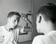 1960 poster print of a teenage boy combing hair in front of a mirror