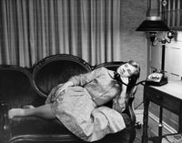 Teenage girl lying on a couch and talking on the telephone poster print.