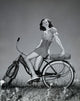 Poster print of a teenage girl smiling while sitting on a bicycle