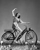 Teenage girl riding a bicycle and smiling poster print