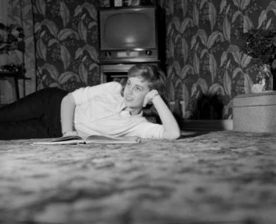 Daydreaming young woman laying on carpet poster print.