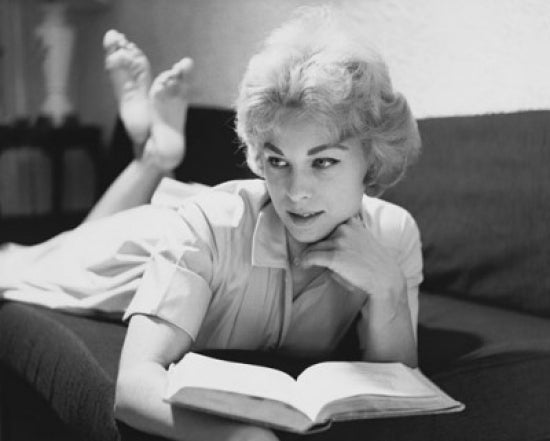 Poster print of a teenage girl lying on a couch with a book.