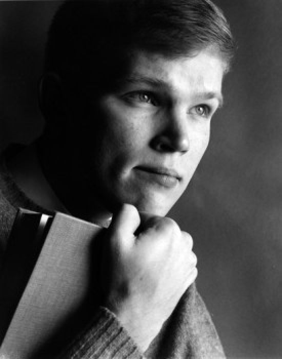 Portrait of teenage boy holding a book, inspiring curiosity and learning.